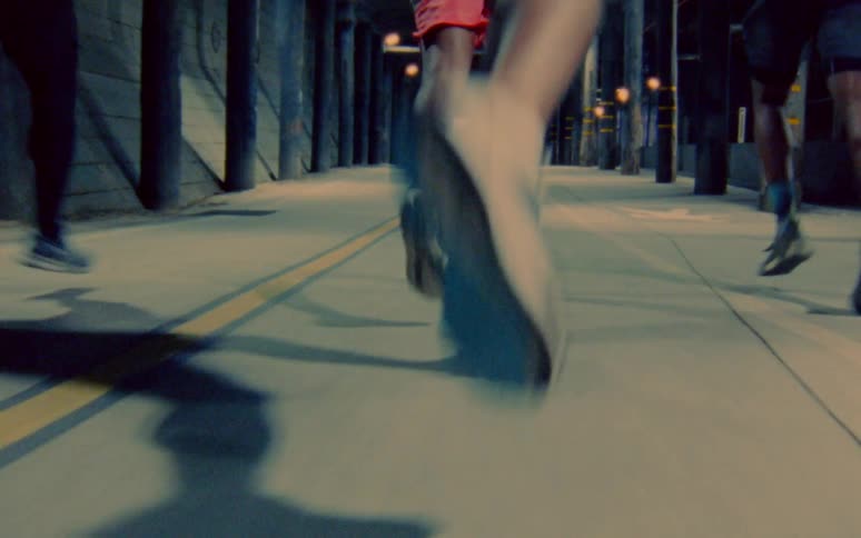 Group of men jogging through a tunnel in the city caught on vintage film