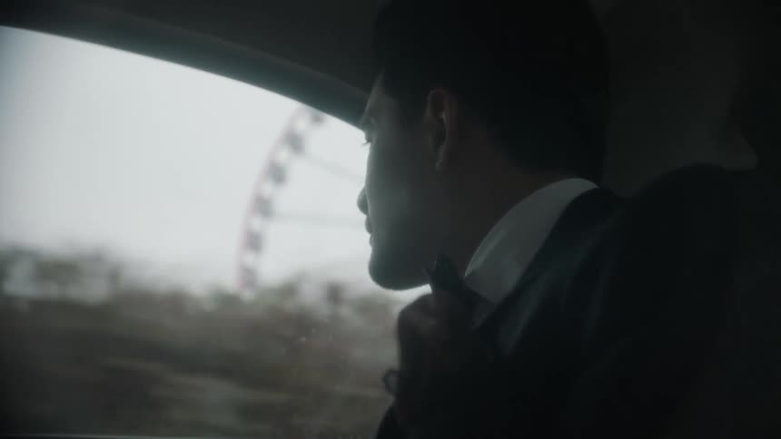 Man looks out the window of a moving vehicle and sees a ferris wheel