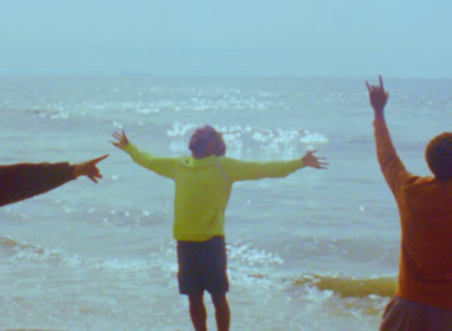Three men are hanging out at the beach together