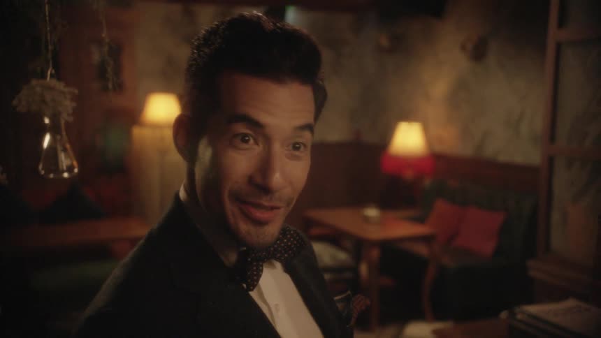 A restaurant employee in a tuxedo shakes hands with a guest