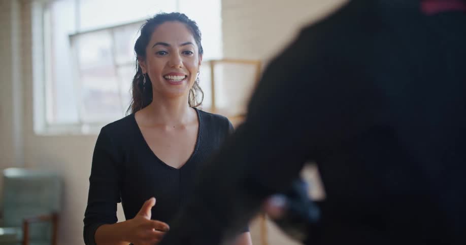 A man and woman discuss dance moves in a dance studio
