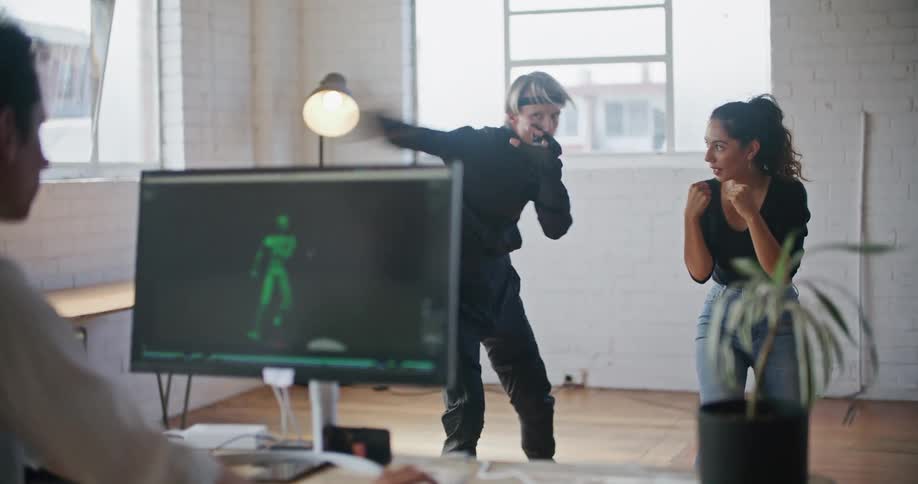 Young fit woman teaching boxing moves to a man wearing a motion capture suit