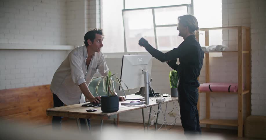 Two men work together to capture actions with a motion capture suit