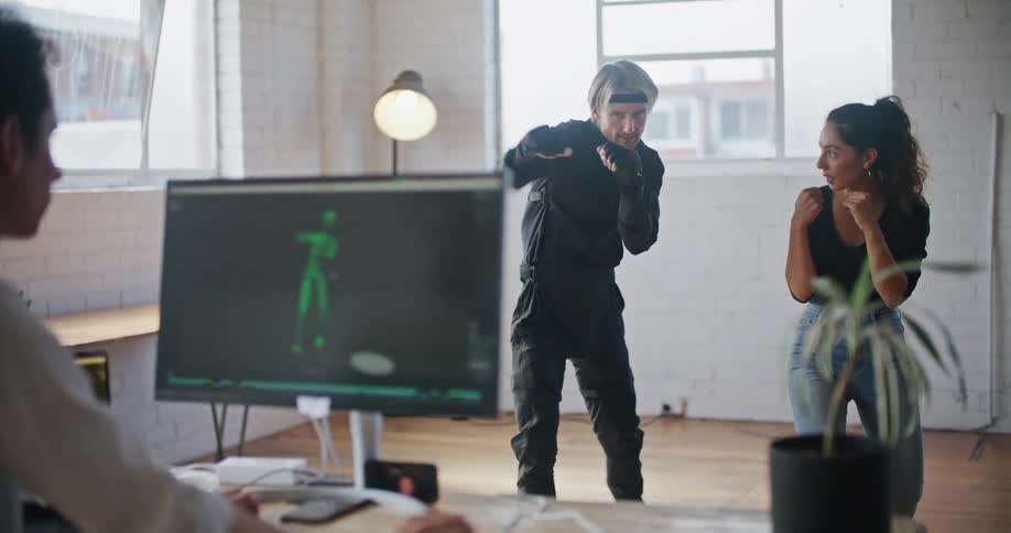 A woman is teaching a man how to punch as he is being recorded