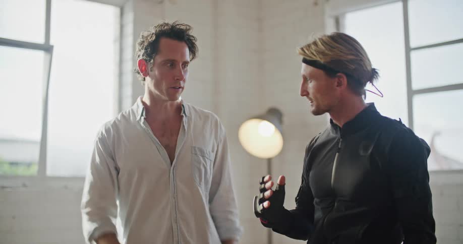 A man directs a motion capture actor in a studio