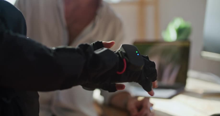 Man in white shirt gives instructions to another man wearing a futuristic motion capture black suit