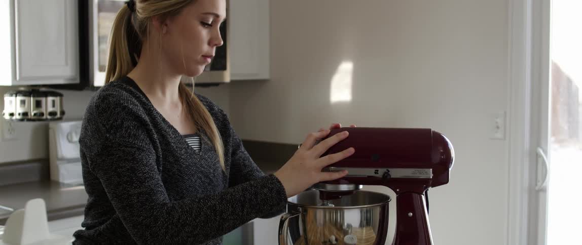 Woman preparing to mix her food with her electric mixer