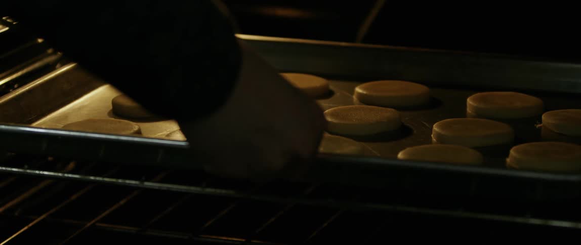 A person puts cookies in the oven