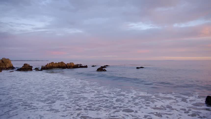 The sun is setting above the ocean waves