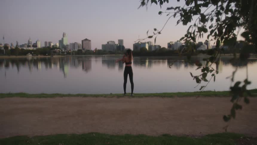A woman is stretching outdoors on the coast