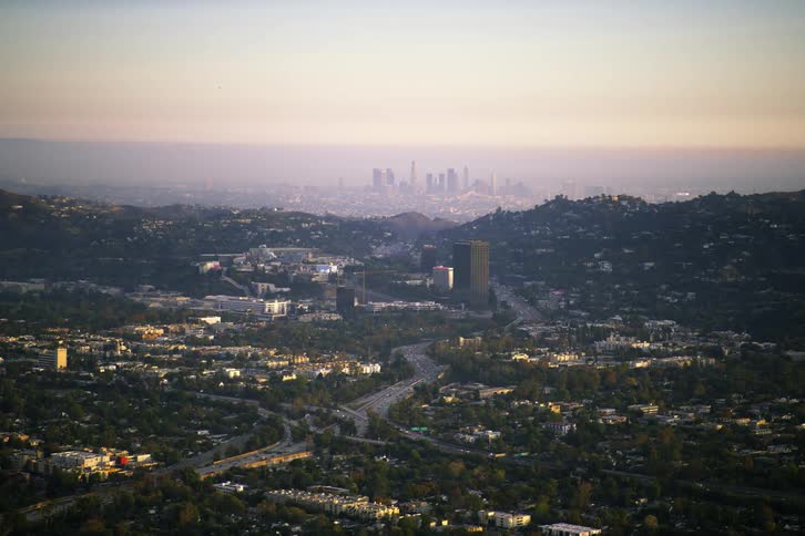Highway passes through neighborhoods heading toward fog covered city