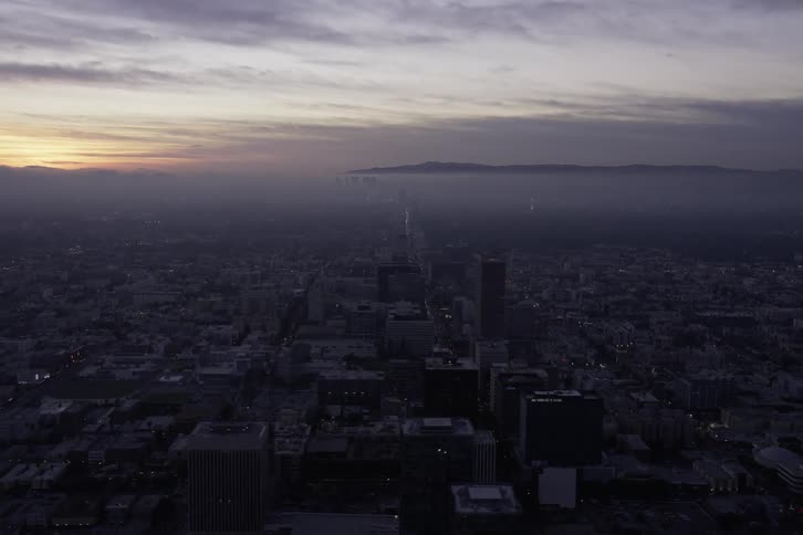 Aerial view of a cityscape is displayed at dusk