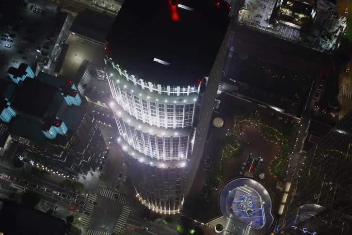 Vehicles travel around the buildings at night