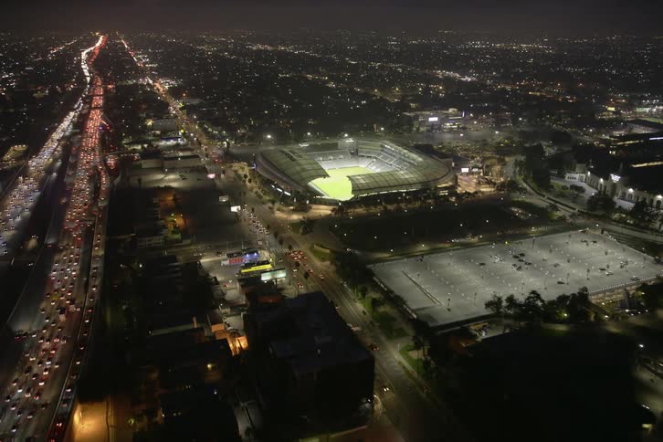 Cars are driving through a downtown city at night