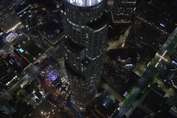 Traffic passes by skyscrapers in a dense city lit up at night