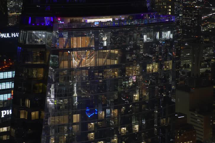 Aerial view of buildings in a city are displayed at night
