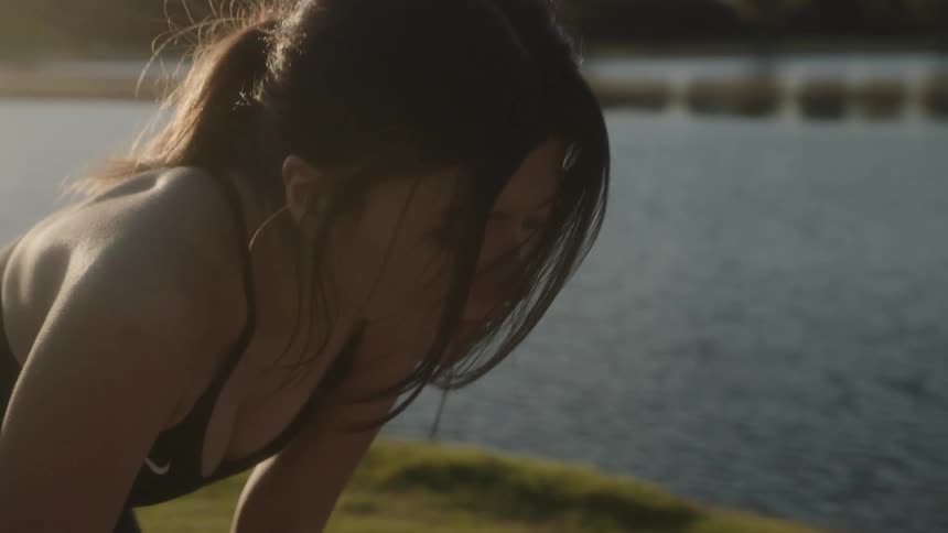 A woman stops to catch her breath while jogging along the city waterfront