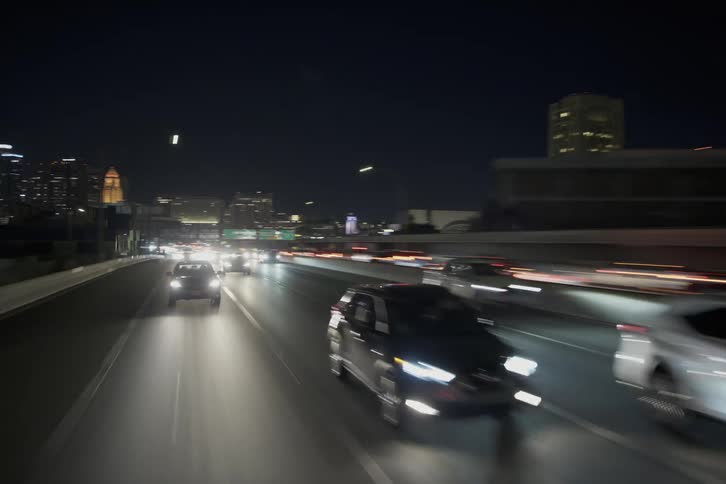 A view of driving down a road in a city at night