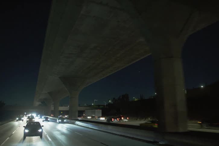 Traffic flows along controlled access highway on both sides of elevated roadway