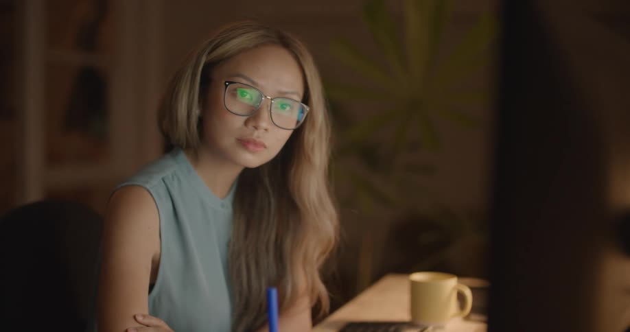 A woman is taking notes at her desk
