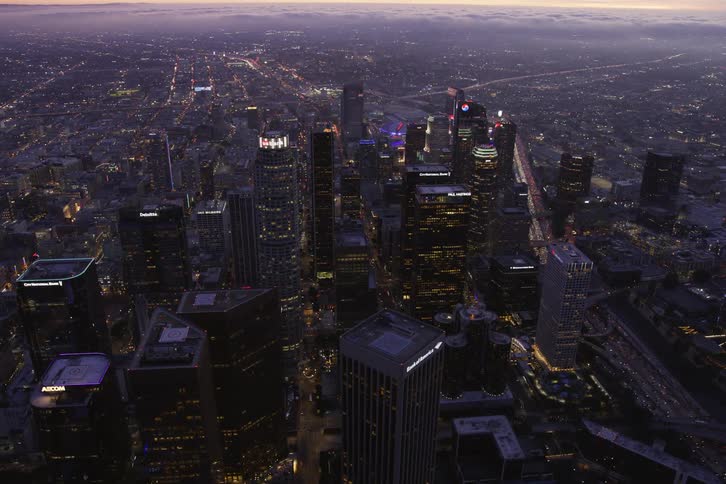 Aerial view of tall buildings in a city is displayed at dusk