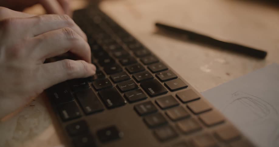 Mans hands type on computer keyboard