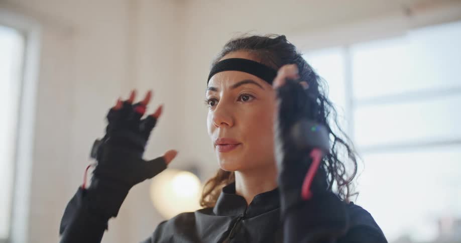 Woman wearing motion capture suit nods then makes gesture of taking a head covering off