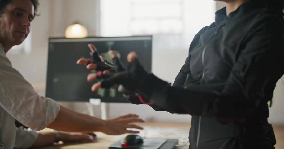 A woman moves her hands and it is mirrored on the computer screen
