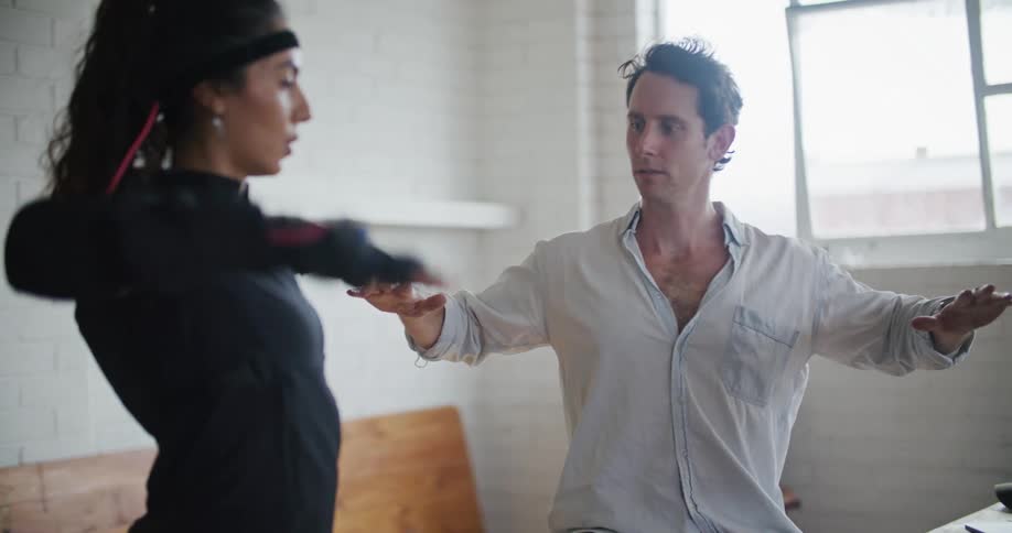 Man directs woman wearing a motion capture suit