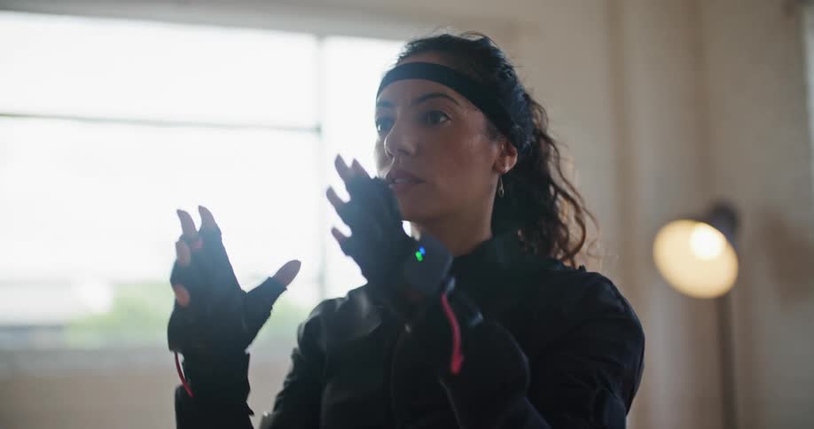 Woman wearing motion capture suit mimes removing helmet