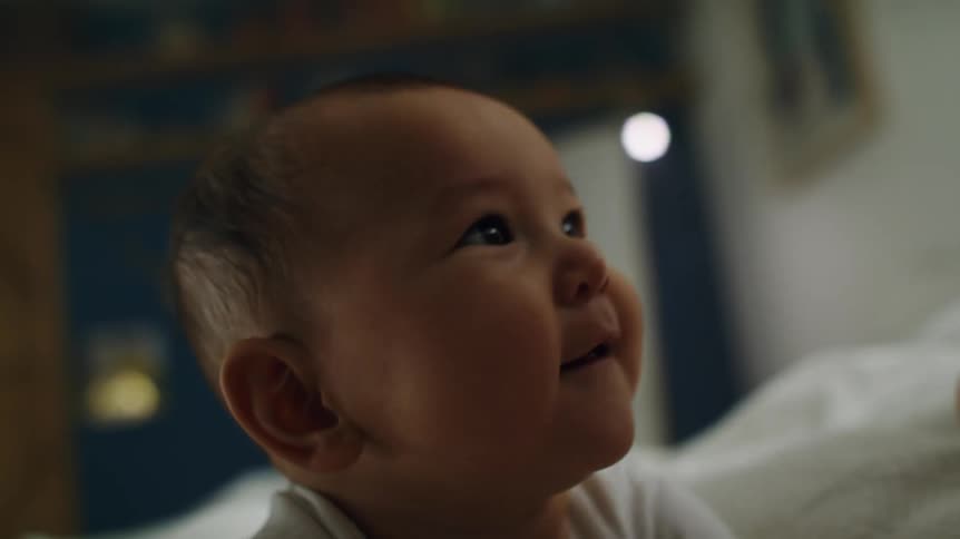 Fabric is dragged over the head of a smiling baby