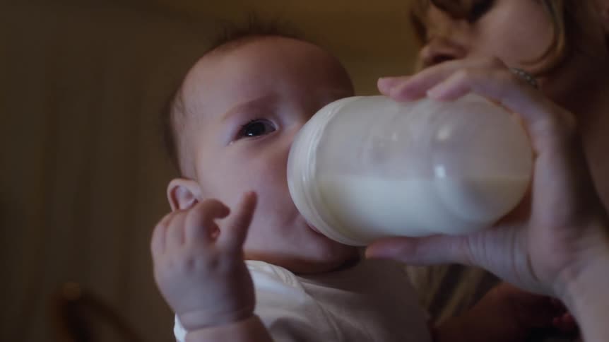 A baby pushes his bottle away during a feeding
