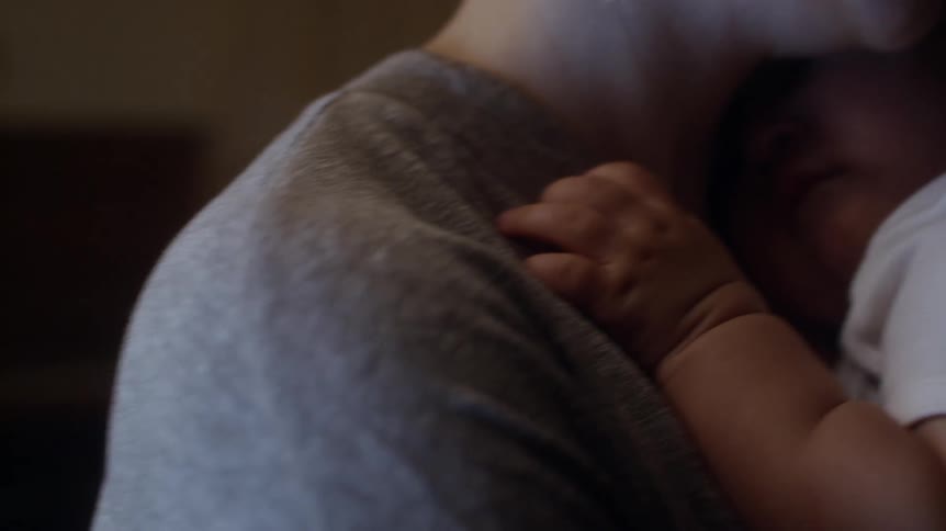 Mother holding and rocking her baby while it is sleeping