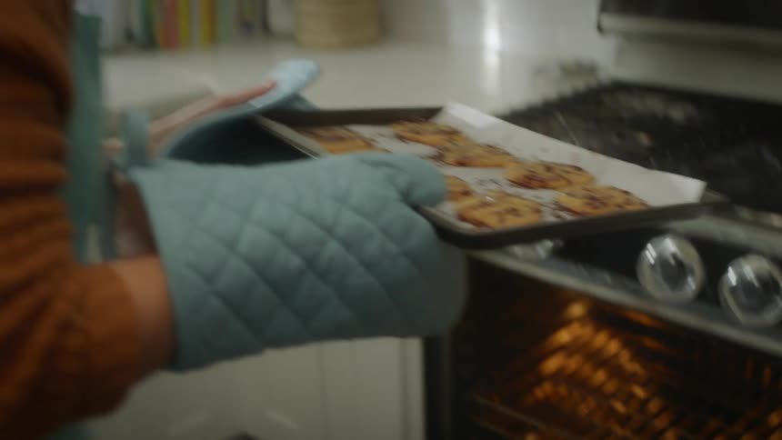 A woman is baking cookies in her kitchen