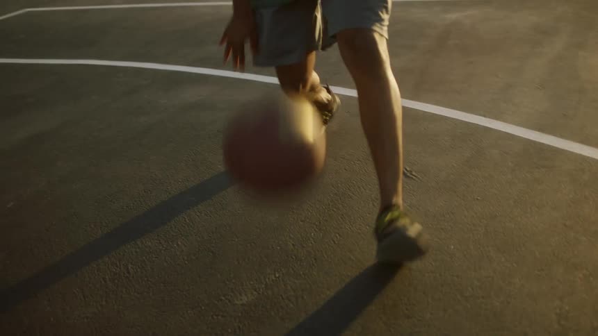 Man with shorts and sneakers plays basketball on court