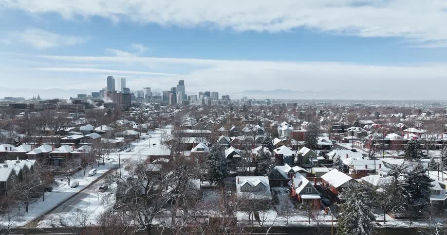Vehicles drive past a suburban neighborhood near downtown