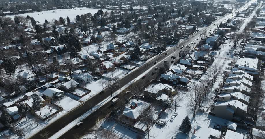 Aerial view of traffic moving through a snow covered town on a winter day