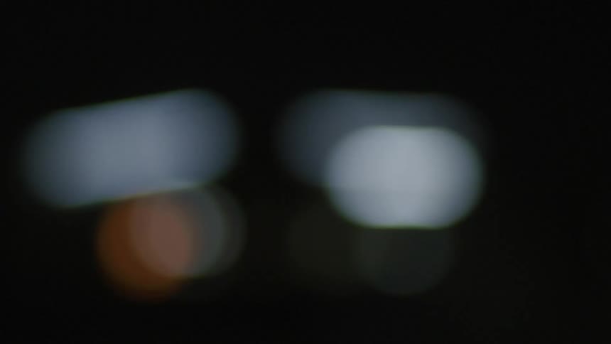 Passing glowing circles of light like city traffic in a blur