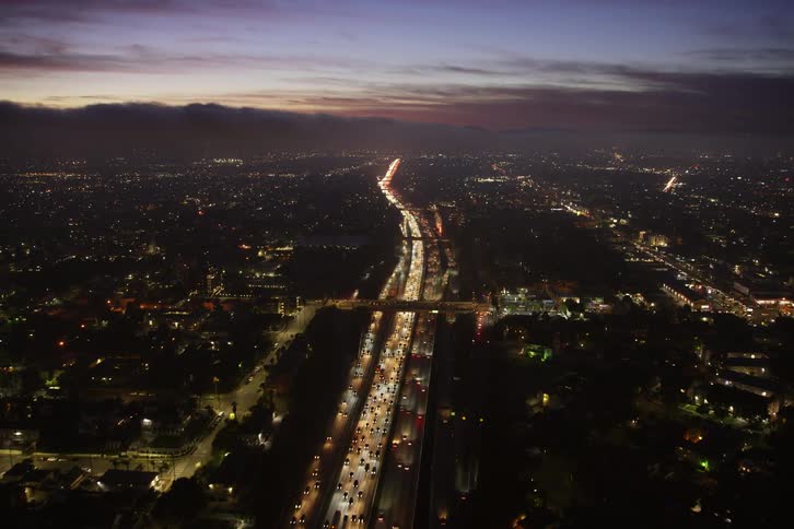 Aerial view of cars driving on a highway at dusk
