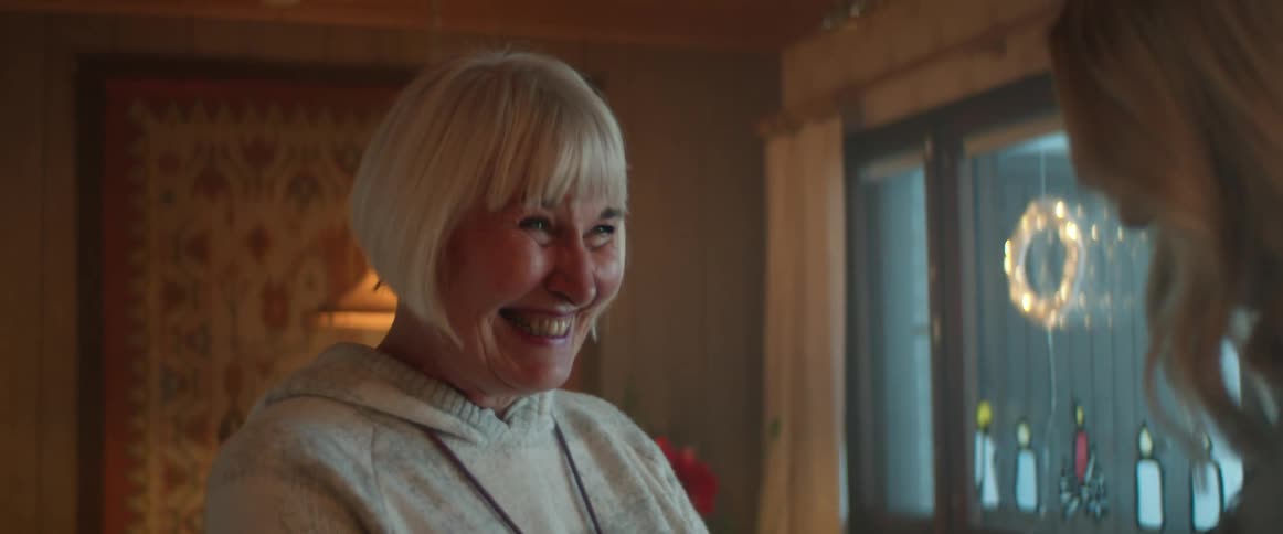 A woman is smiling and talking to another woman