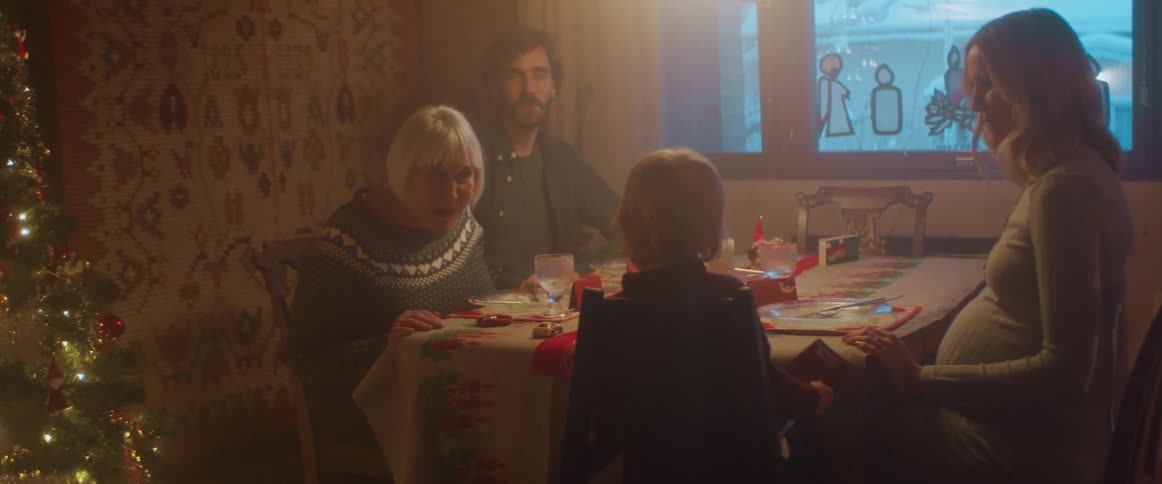 A woman laughs with her grandchild as she joins the family for dinner