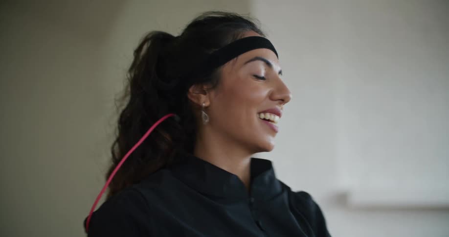 A woman smiles big while moving her arms in a swimming motion and giving instruction