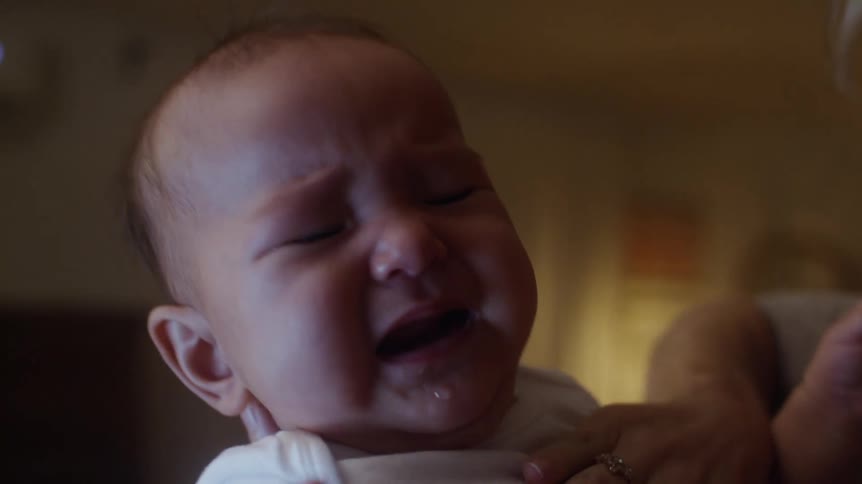 A mother is rocking her crying baby