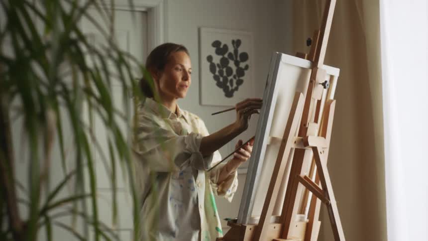 A woman is painting on a canvas indoors