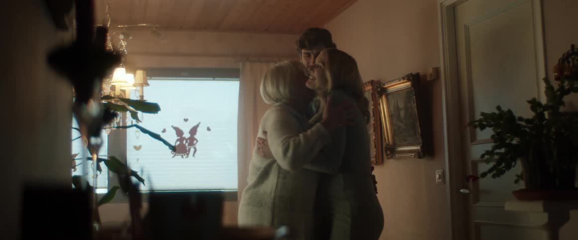 A couple hug an older woman