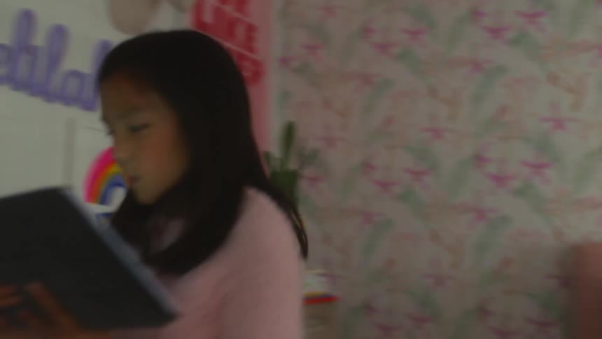 Girl lying down on her bed in her bedroom using her tablet and then standing up and going to another room