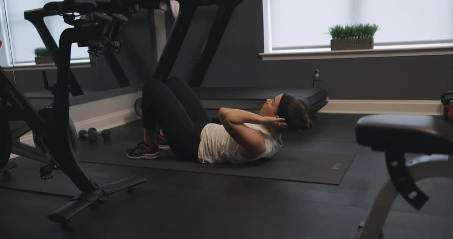 A woman is working out in a gym during the day