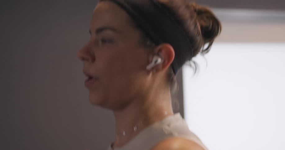 A woman is jogging on a treadmill during the day