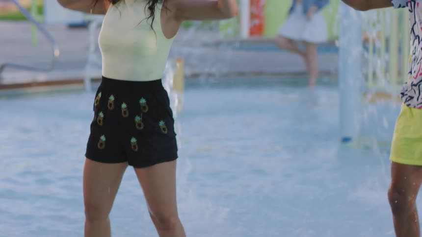 Young people dance together in a water park