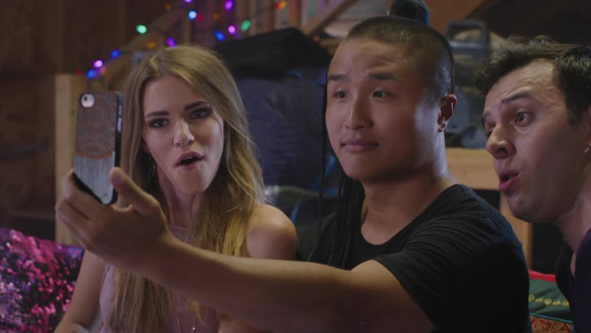 Friends set up and pose for a selfie on a smartphone